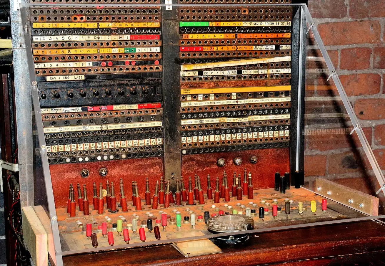 A vintage telephone switchboard, its rows of jacks and patch cords for connecting calls